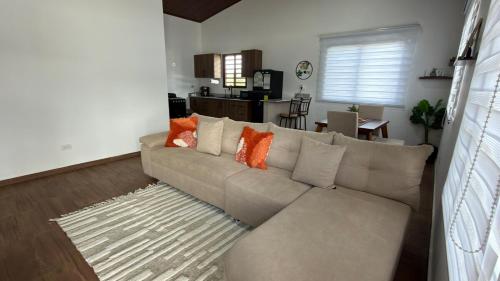 a living room with a gray couch with orange pillows at Cozy Calm Refuge in Alto Boquete