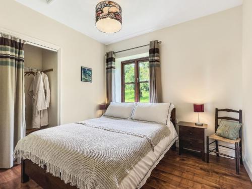 a bedroom with a bed and a window at Beehive Cottage Culbone in Porlock