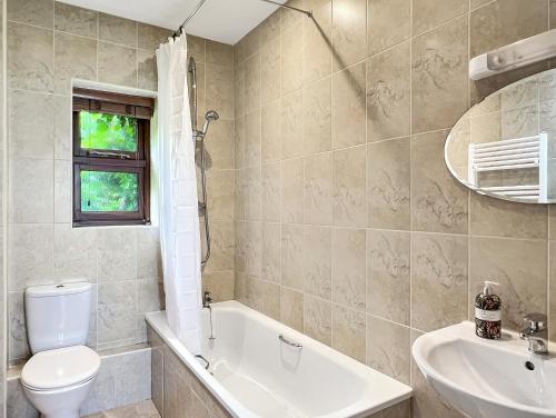 a bathroom with a toilet and a sink and a tub at Beehive Cottage Culbone in Porlock