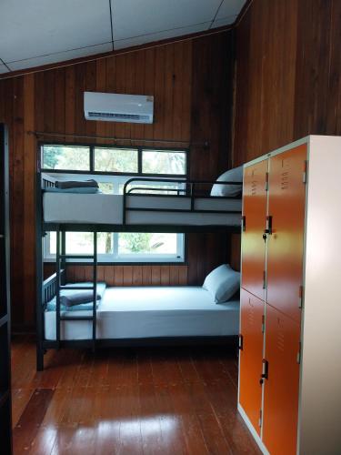 two bunk beds in a room with a window at Honey You HOSTEL in Ban Khlong Mat