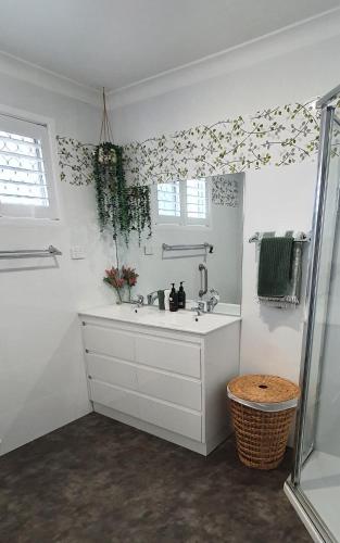 a white bathroom with a sink and a window at Marigold House in Rockville