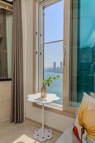 a room with a window and a table with a plant on it at 광안리 써니 스테이 #무료주차 in Kwangan-dong