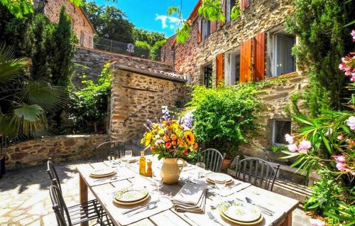 a wooden table with flowers on top of a patio at Authentique Villa Piscine in Taulis