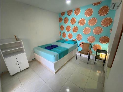 a small bedroom with a bed and two chairs at Tamarindo in Santa Marta