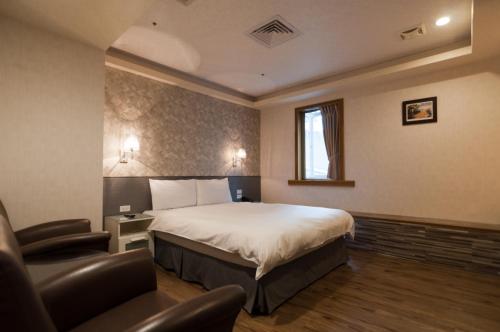 ein Hotelzimmer mit einem Bett und einem Stuhl in der Unterkunft 泊居旅店 Oursinn Hotel in Taipeh