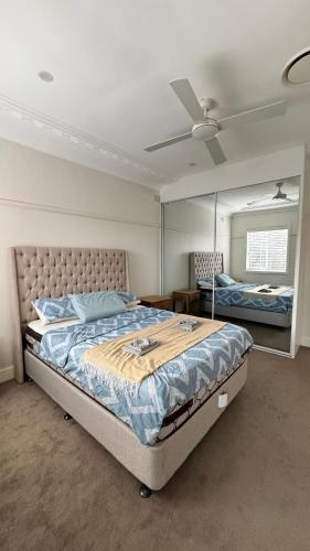 a bedroom with a large bed and a mirror at Main road apartment in Sydney