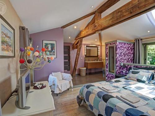 a bedroom with a large bed and a living room at Gîte au cœur d'un village médiéval, charme et confort moderne - FR-1-496-125 in Chagnon