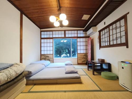 ein Zimmer mit zwei Betten und einem Fenster in der Unterkunft Hostel Caranashi Osaka Imazato in Osaka