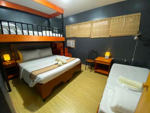a bedroom with a bunk bed and a desk at Angkel's Place in Bangued