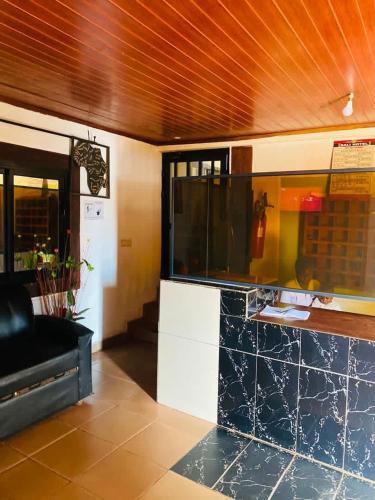 a restaurant with a counter and a black couch at Hôtels Bali in Yaoundé