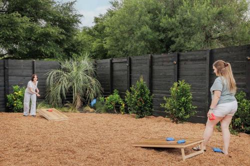 two women playing a game in a backyard at Modern Designer Home with Shared Pool in Austin