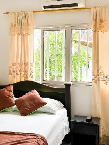 a bedroom with a bed and two windows at Hotel Porton De Oriente in Puerto Triunfo