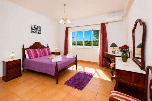 a bedroom with a purple bed and a window at Villa Sol Nascente in Porches