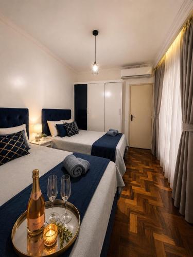 a hotel room with two beds and two wine glasses at Roupa cama Wi-Fi garagem ar Cond beira mar 50 m in Tramandaí