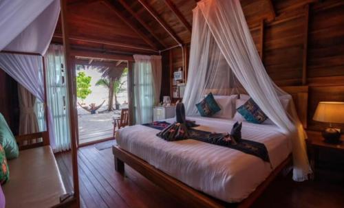 a bedroom with a bed with a canopy at Lipe Beach Resort in Ko Lipe
