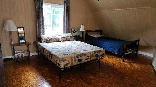 a bedroom with two beds and a window at The Cabin at Solitude Junction in Opdyke