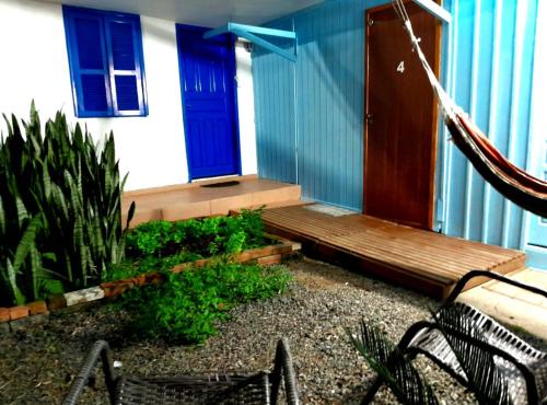 a porch with a blue door and a wooden bench at Pousada Vino & Leta O seu parador no centro in Grão Pará