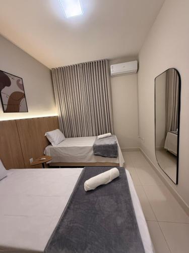 a hotel room with two beds and a mirror at Apto Mais Decor 02 in Salinas