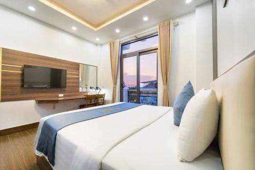 a bedroom with a large bed and a television at Winston Hotel Riverside in Ho Chi Minh City