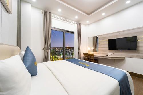 a hotel room with a bed and a desk and a television at Winston Hotel Riverside in Ho Chi Minh City