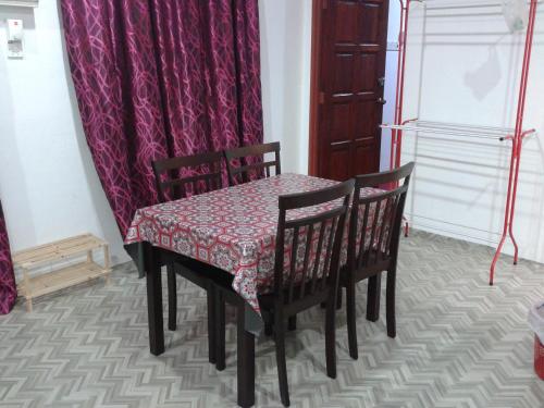 uma mesa com duas cadeiras e uma mesa com uma toalha de mesa em NUE Guesthouse em Kota Bharu