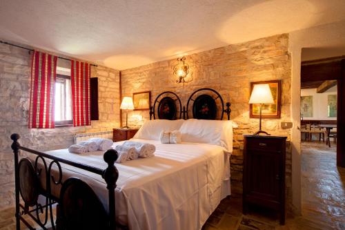 a bedroom with a large bed with towels on it at Riserva Privata San Settimio in Arcevia