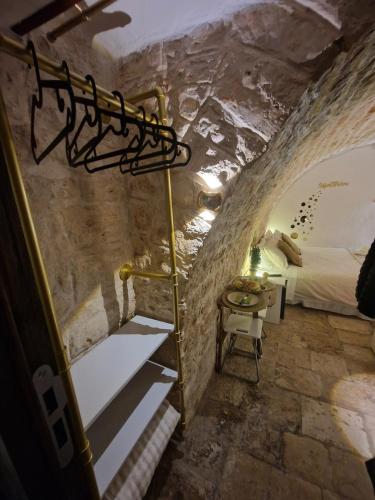 a bedroom in a cave with a bed and a table at Soffio di Pietra in Castellana Grotte