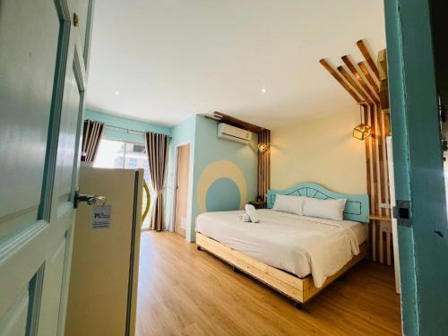 a bedroom with a bed with a blue wall at Castaway's hua hin in Hua Hin