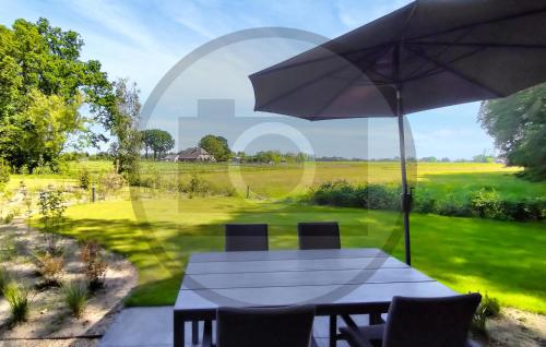 a table and chairs with an umbrella in a yard at Tiny House 10 Met Hottub in Wenum