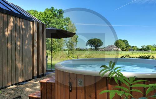 a jacuzzi tub with a view of a field at Tiny House 10 Met Hottub in Wenum