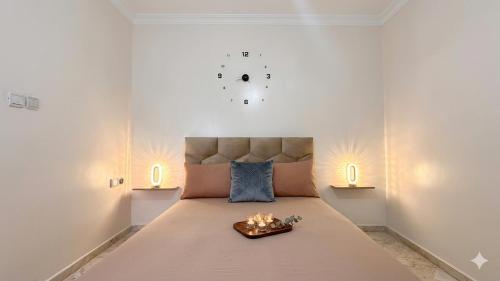 a bedroom with a large bed with a clock on the wall at Cozy Apartment Near Rabat & Beach in Temara