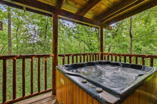 a hot tub on the deck of a tree house at Mountain Joy cabin in Gatlinburg