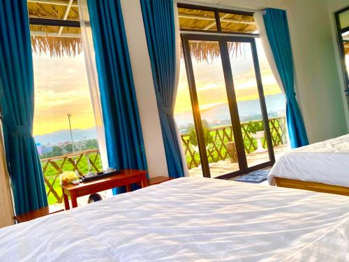 a bedroom with a bed and a window with a view at Mường Thanh Garden Stay in Dien Bien Phu