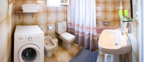 a bathroom with a washing machine and a sink at Villa Olive Grove and sea view in St. Spyridon Corfu