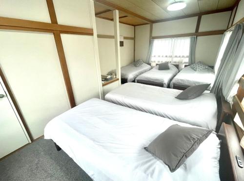 a small room with three beds in it at くつろぎのお宿 やわや 駅北 in Toyama