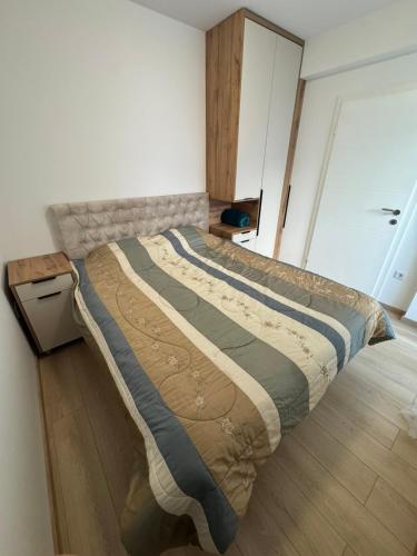 ein großes Bett in einem Schlafzimmer mit Holzboden in der Unterkunft Petica in Brčko