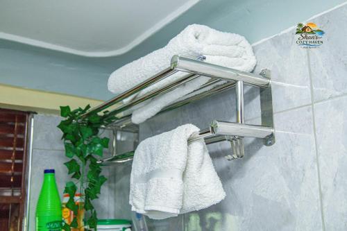 a towel rack on a bathroom wall with towels at Shan cozy haven in Jinja