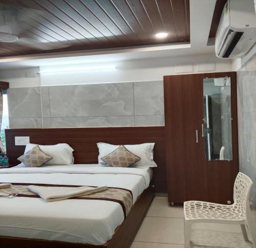 a bedroom with two beds and a chair in it at Annai Ocean Park in Velankanni