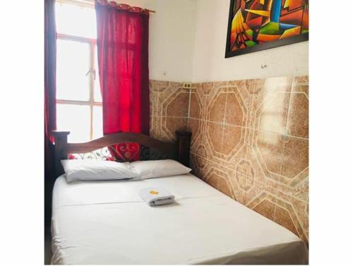a bed in a room with a window and avertisement at Hotel La Palma Girardot in Girardot