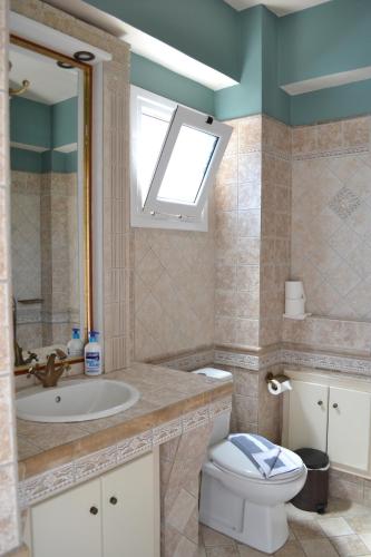 a bathroom with a sink and a toilet and a window at Edem Studios in Syvota
