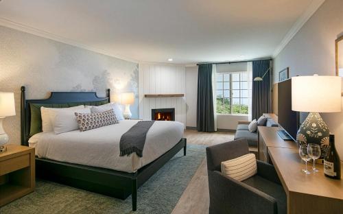 a bedroom with a bed and a living room with a fireplace at Fireside Inn on Moonstone Beach in Cambria