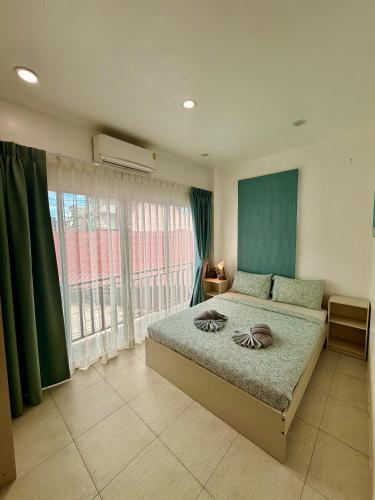 a bedroom with a bed and a large window at Drift Inn Kata Beach, Guest House in Kata Beach