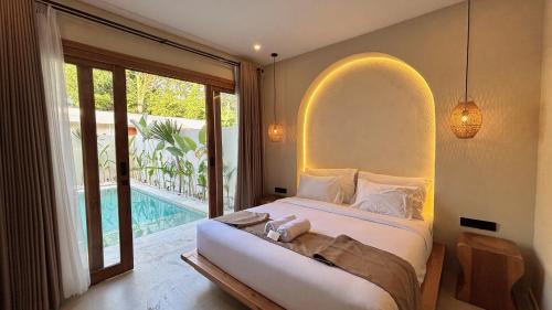 a bedroom with a large bed with a large window at Oasis Dune Villas Lombok in Kuta Lombok