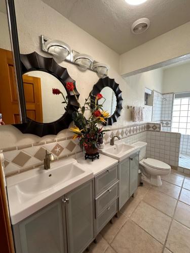 a bathroom with two sinks and a toilet and mirrors at Almost heaven beach house in Puerto Peñasco