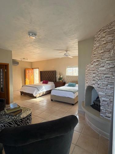 a bedroom with two beds and a stone fireplace at Almost heaven beach house in Puerto Peñasco