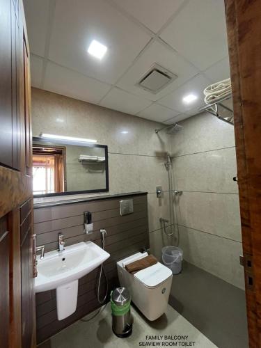 a bathroom with a sink and a toilet and a mirror at Cherai Beach View Heritage in Cherai Beach