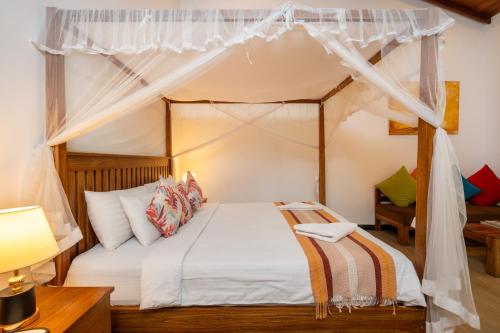 a bedroom with a bed with a canopy at Wasala Banquets & Nature Resort in Radawana