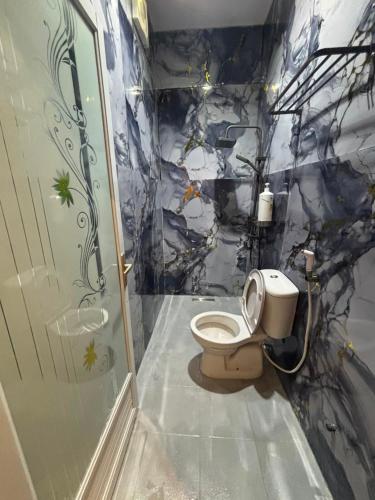 a bathroom with a toilet in a room with a shower at Happy Garden in Kampong Tenompok