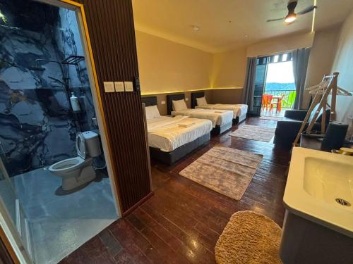 a hotel room with three beds and a bathroom at Happy Garden in Kampong Tenompok