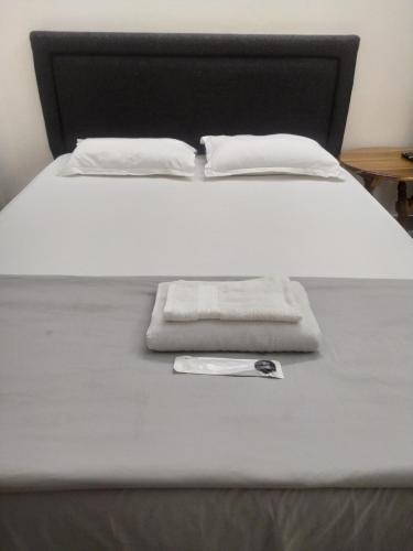 a bed with a white blanket and a towel on it at Viki homestay in Dimapur